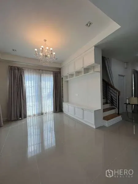 Detached House for rent or sale in Khan Na Yao, Bangkok - Dining area by the staircase with built-in storage and glass doors to the patio.