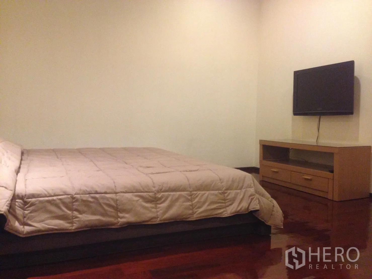 公寓 出租在Watthana, Bangkok - 卧室配大床，墙挂电视与木质电视柜，实木地板光泽亮丽。