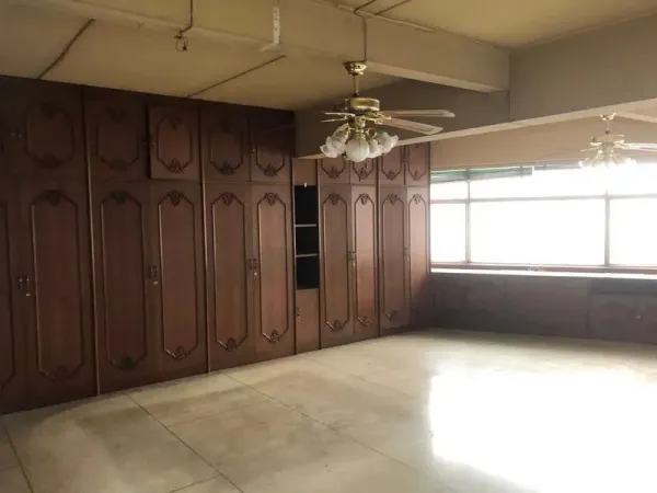 Shophouse for rent in Khlong Toei, Bangkok - Large room with full-height wooden wardrobes, ceiling fans and wide windows.