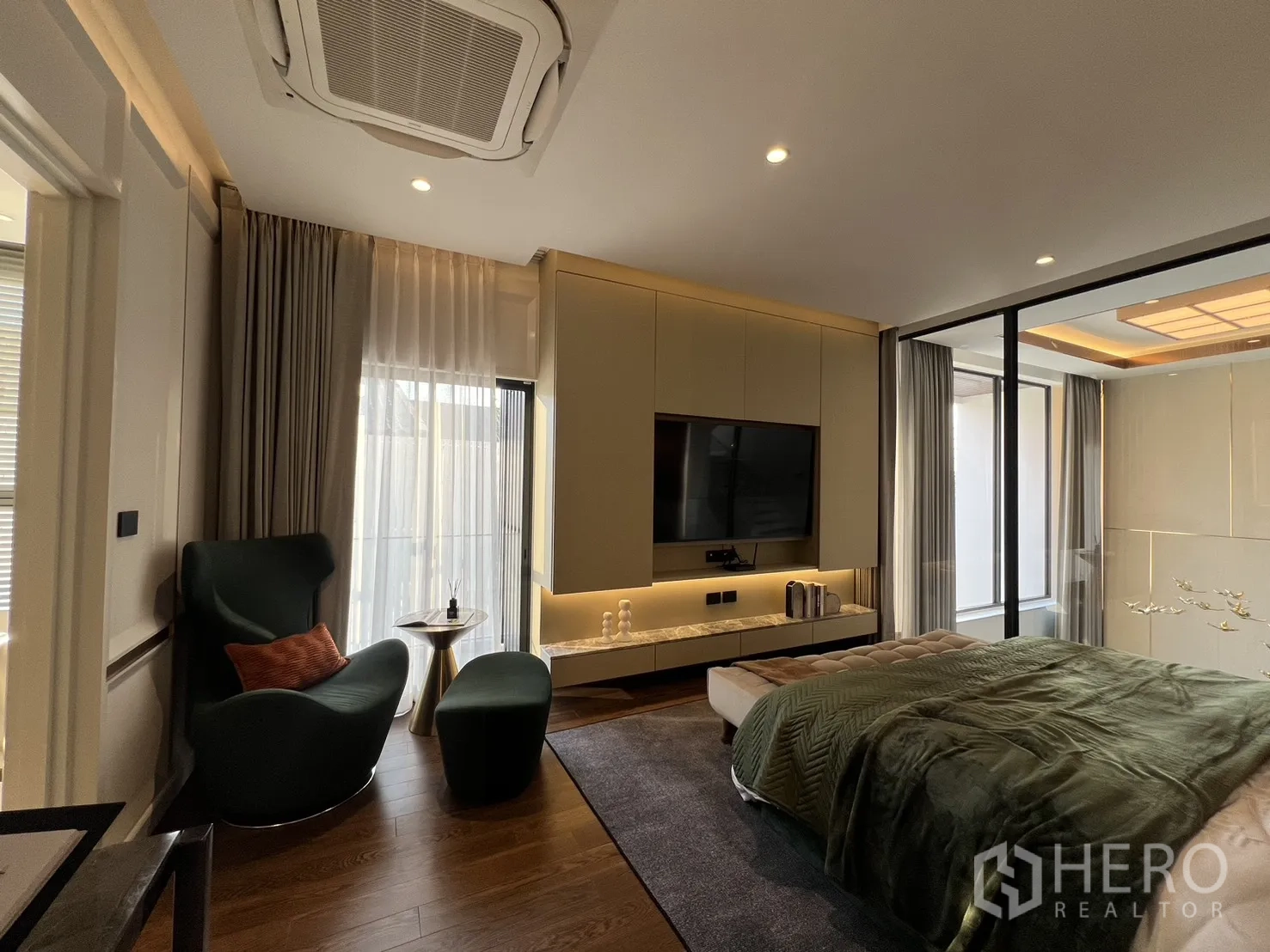 Detached House for sale in Lat Phrao, Bangkok - Master bedroom with seating nook, TV wall and glass viewing panel to the void.