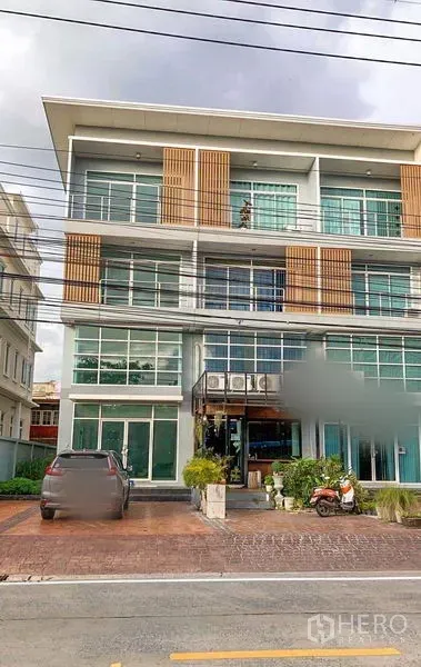 带办公室的家 出租在Min Buri, Bangkok - 民武里现代多层商业建筑，玻璃立面与前方停车区