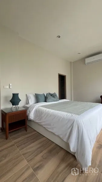 独立式住宅 出租在Lat Krabang, Bangkok - 明亮卧室，双人床、床头柜与空调。