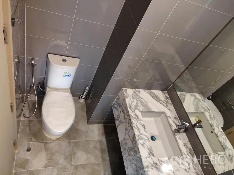 公寓 出租在Ratchathewi, Bangkok - 浴室设大理石双台盆、超大镜面与坐便器。