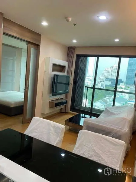 Condominium for rent in Bang Rak, Bangkok - Open-plan living and dining area with balcony and skyline outlook.