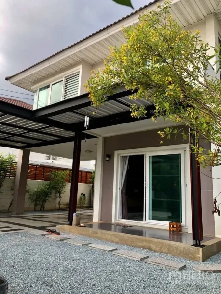 Detached House for rent or sale in Bang Phli, Samut Prakan - Front porch with sliding glass door, metal carport roof and landscaped gravel yard.