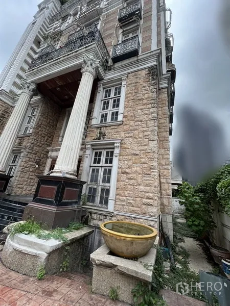 带办公室的家 出租在Huai Khwang, Bangkok - 侧立面石墙与双立柱，花槽与步道相伴。