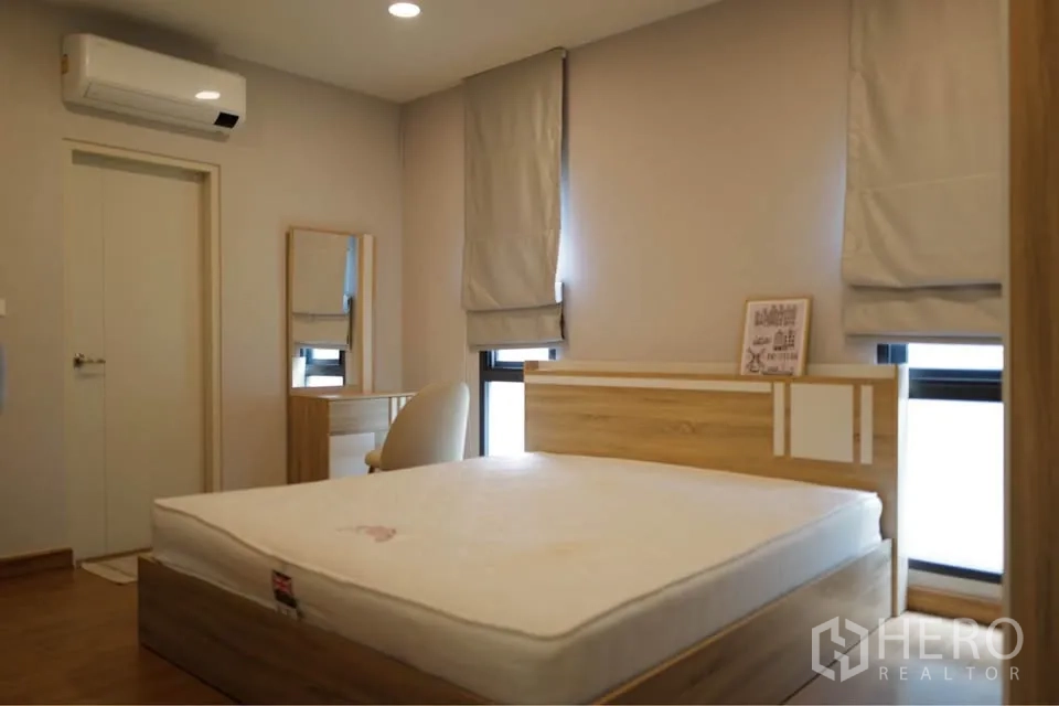 Detached House for rent or sale in Bang Phli, Samut Prakan - Simple bedroom with wooden bed, vanity desk, and wall-mounted air conditioner.