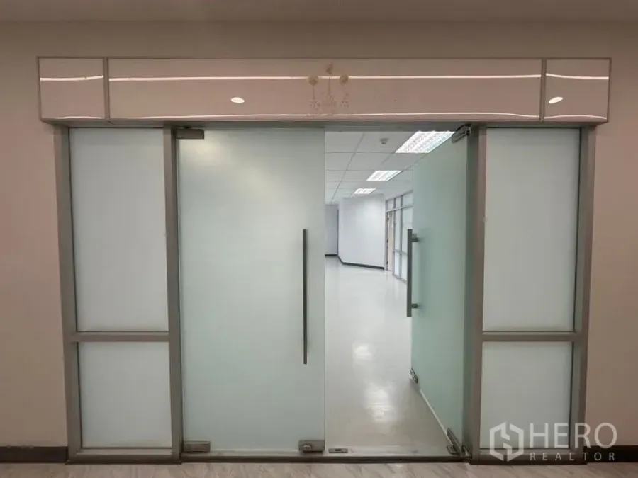 Office Space for rent in Bang Rak, Bangkok - Frosted-glass office entrance with metal handles leading to the workspace.