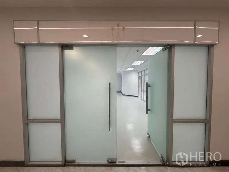 Office Space for rent in Bang Rak, Bangkok - Frosted-glass office entrance with metal handles leading to the workspace.