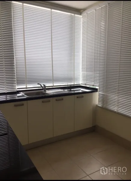 公寓 出租在Watthana, Bangkok - 转角厨房，黑色台面与双水槽，百叶窗环绕采光好。