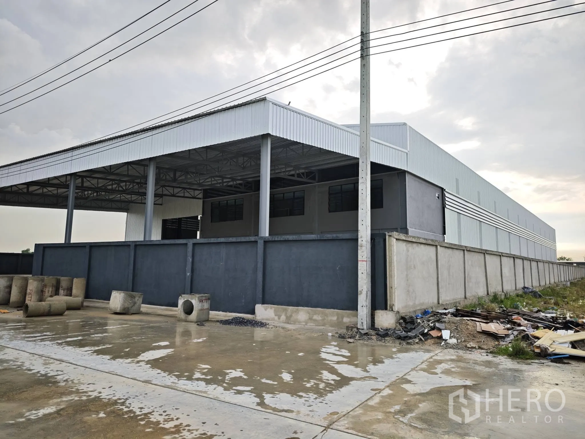 仓库 for rent or sale in Bang Phli, Samut Prakan - 仓库侧立面，围墙与有顶装卸区一并可见。