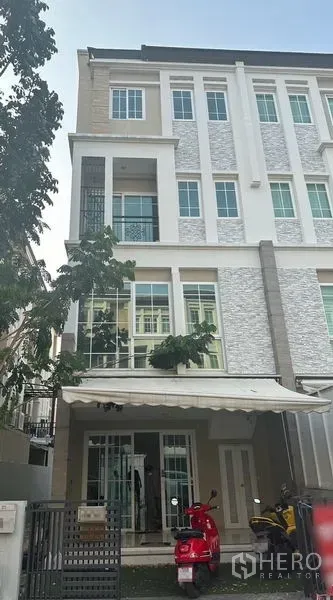 Home Office for rent in Bang Na, Bangkok - Modern four-storey home office facade in Bang Na with large windows, awning and gated entrance.