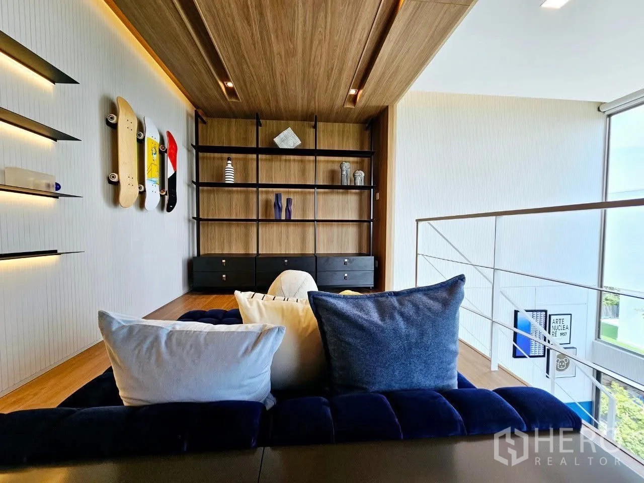 Detached House for rent in Saphan Sung, Bangkok - Loft lounge with built-in shelves and skateboard wall decor.