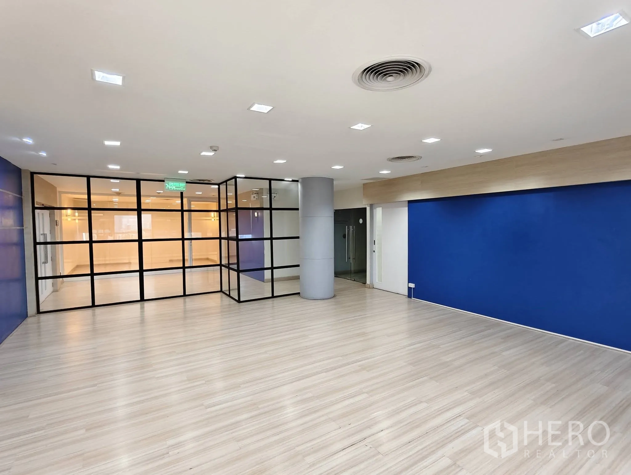 Office Space for rent in Lak Si, Bangkok - Open area with grid-framed glass partition and blue wall.