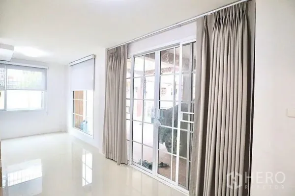 带办公室的家 出租在Bang Sue, Bangkok - 一层明亮房间，推拉玻璃门、窗帘与高光瓷砖地面。