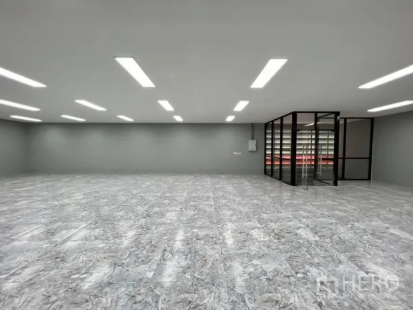 Warehouse for rent in Sai Mai, Bangkok - Large bright office space with LED lighting, marble-look flooring and a glass-walled meeting room.