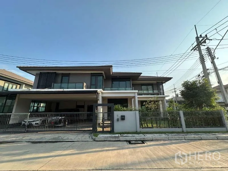 Detached House for sale in Lam Luk Ka, Pathum Thani - Front facade showing gated entrance and large covered carport.