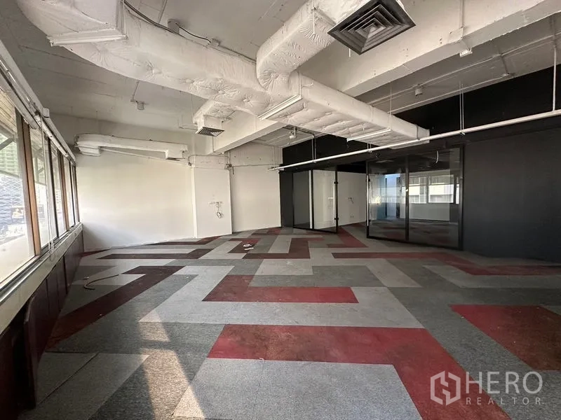 办公空间 出租在Watthana, Bangkok - 几何拼色地毯的工作区，管道式天花，带玻璃隔断会议室。