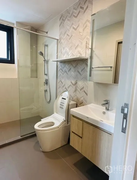 Condominium for rent - Modern bathroom with glass shower enclosure and herringbone tile.