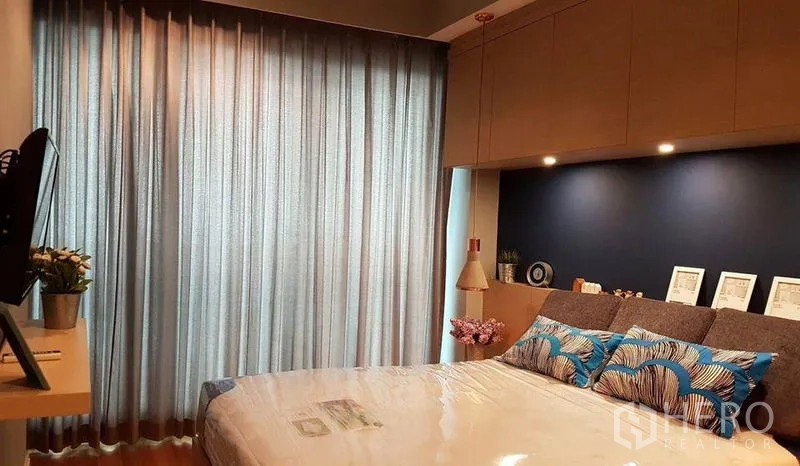 公寓 出租在Khlong San, Bangkok - 卧室配整面窗帘、蓝色特色墙与床头吊灯