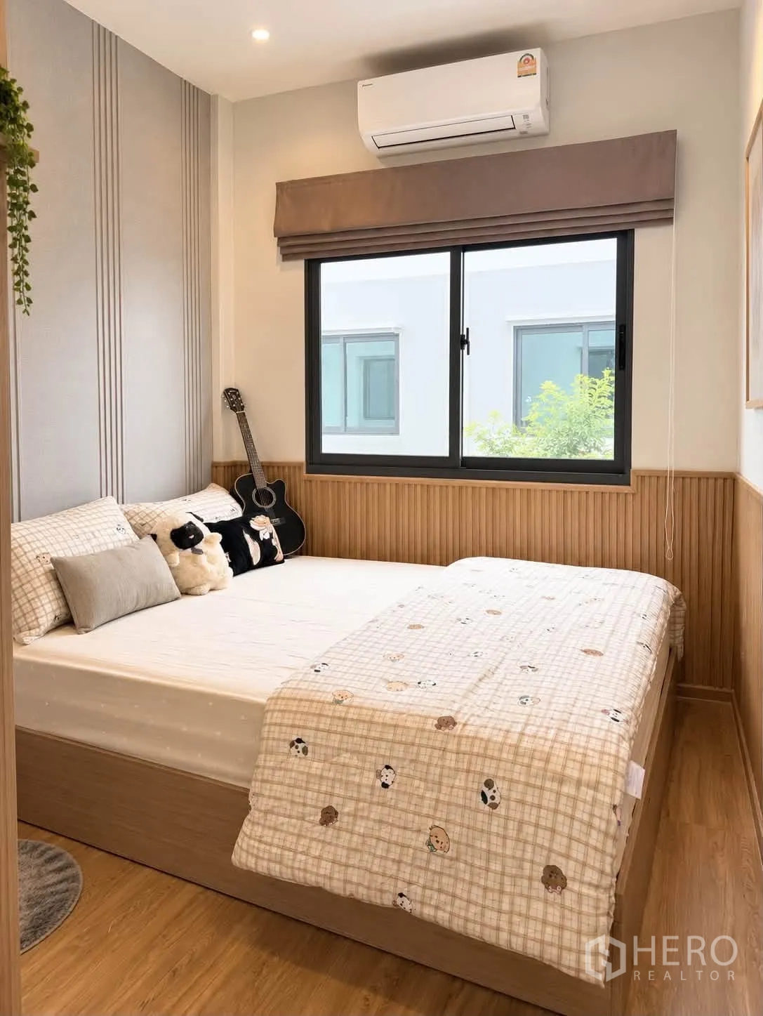 Townhouse for rent in Bang Phli, Samut Prakan - Bedroom view with window, air conditioner, and guitar beside the bed.