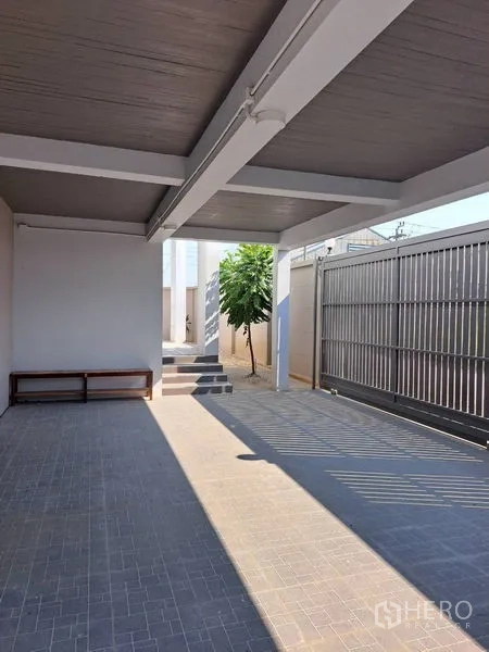 独立式住宅 出租在Prawet, Bangkok - 有顶车棚，地砖铺设，金属推拉大门入口。