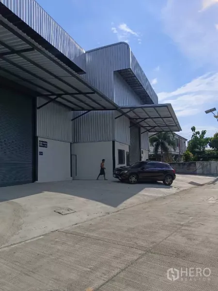 Warehouse for rent in Bang Phli, Samut Prakan - Row of metal-clad warehouses with covered loading bays and a spacious driveway.