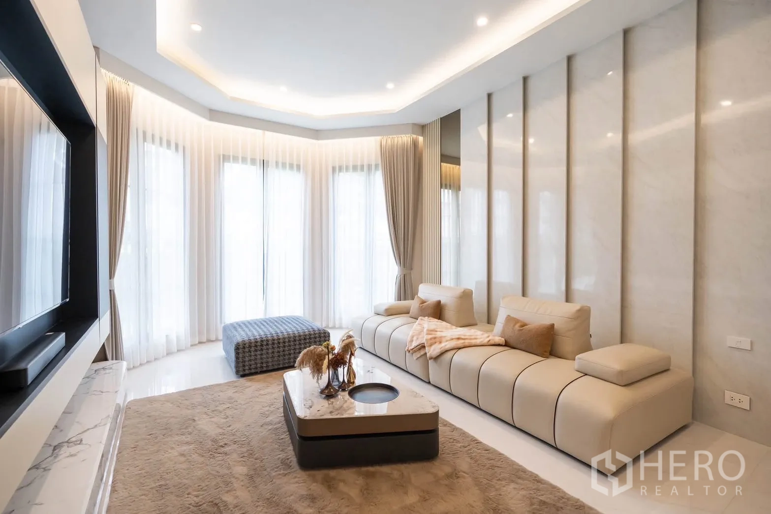 Detached House for rent or sale in Bang Kapi, Bangkok - Cozy family lounge with curved bay windows, soft sofa, and coffee table.