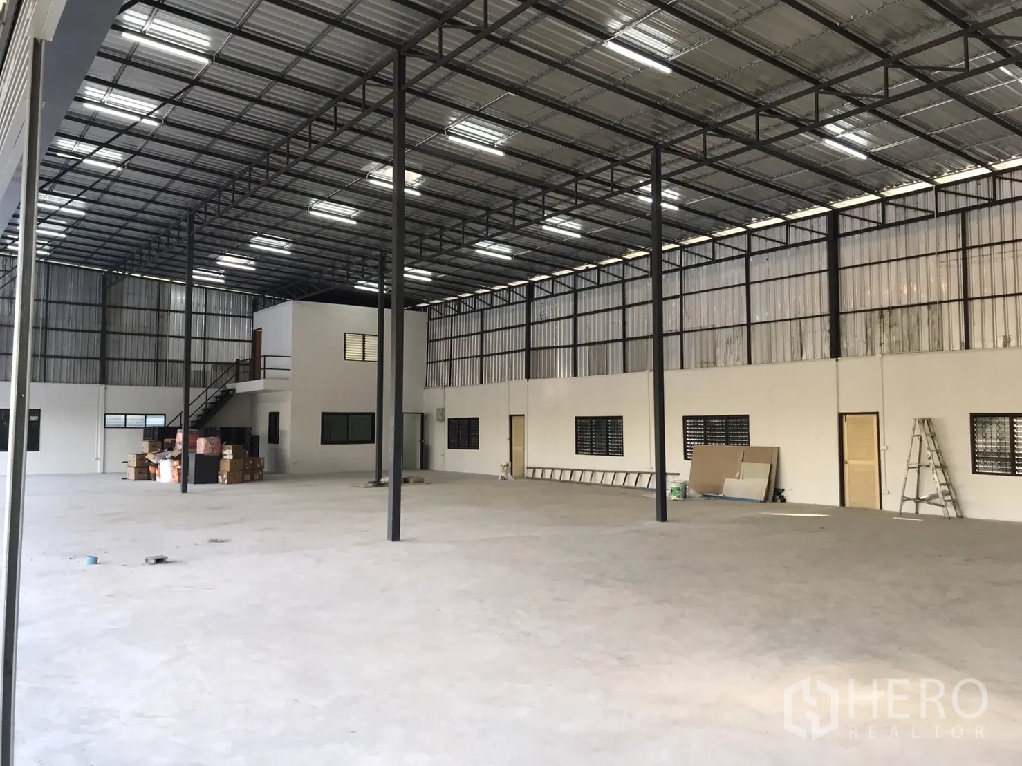 Warehouse for rent in Lam Luk Ka, Pathum Thani - Open-plan storage floor with steel columns, bright roof lights and white partition walls.