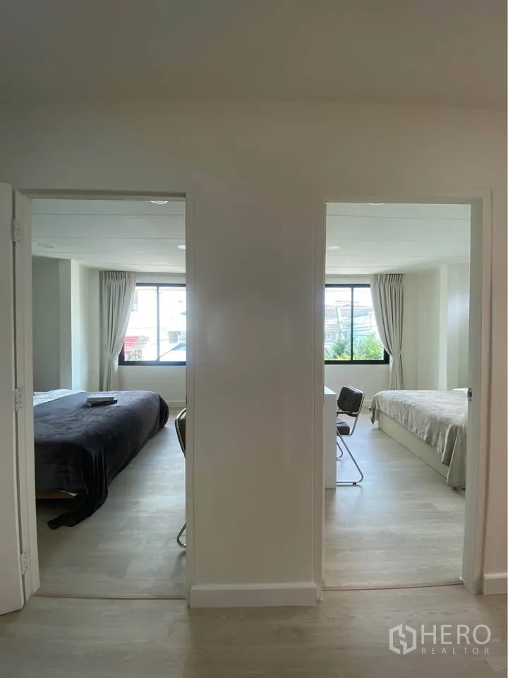 บ้านเดี่ยว for rent in Huai Khwang, Bangkok - มุมมองจากโถงไปยังห้องนอนสองห้องที่มีหน้าต่างบานใหญ่และโต๊ะทำงาน