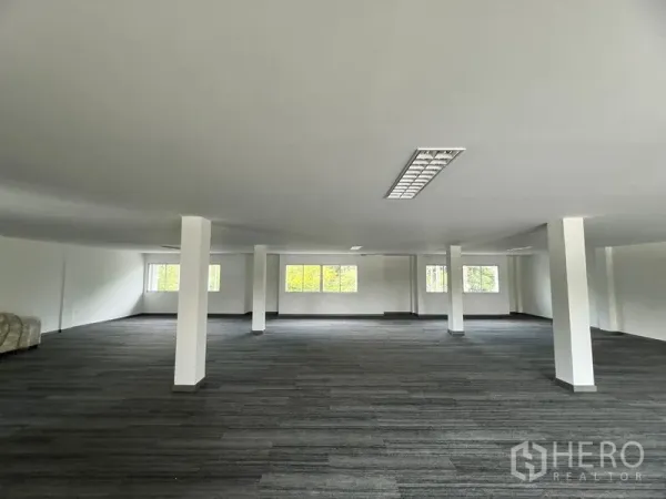 Retail Space for rent in Huai Khwang, Bangkok - Spacious open‑plan retail floor with white columns, carpet tiles, and ceiling lighting with natural light from multiple windows.