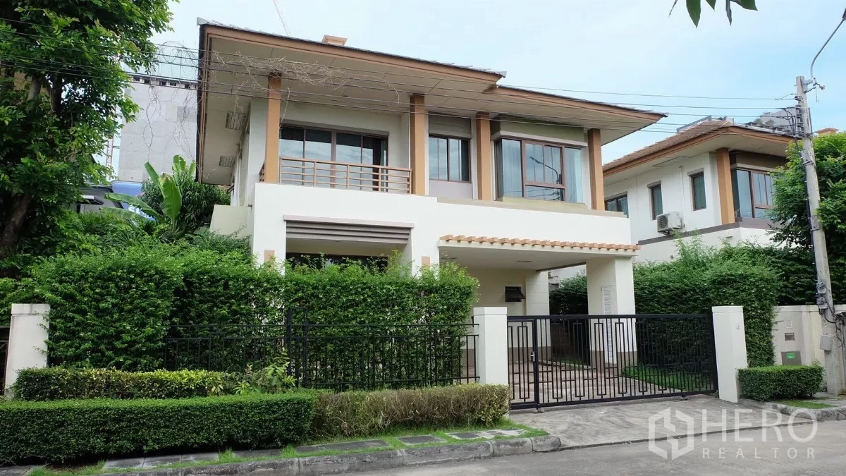 Detached House for sale in Bang Phli, Samut Prakan - Two-storey detached house with gated entrance, balcony and lush hedge frontage.