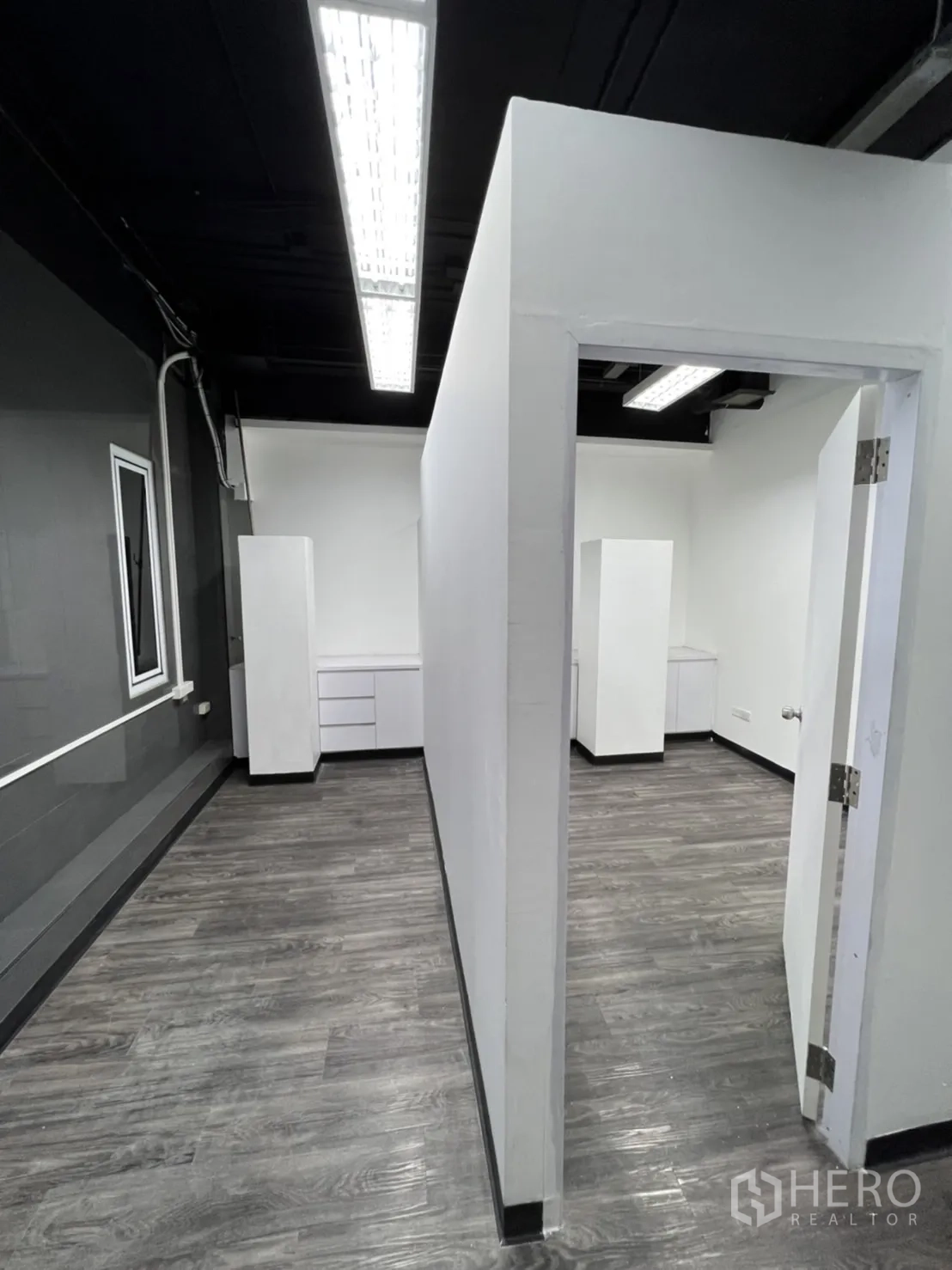 Retail Space for rent in Sathon, Bangkok - Partitioned workspace with white walls, exposed black ceiling and gray wood floors.