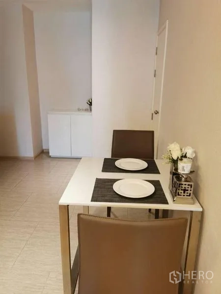 Condominium for rent or sale in Watthana, Bangkok - Two-seat dining nook with simple walls and tiled flooring.