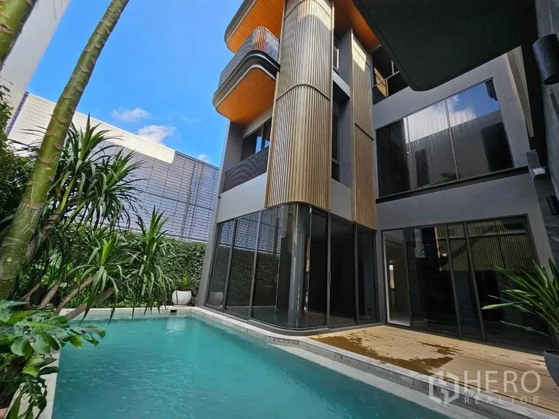 Detached House for rent in Wang Thonglang, Bangkok - Rear exterior of the contemporary home with vertical cladding beside the pool deck.
