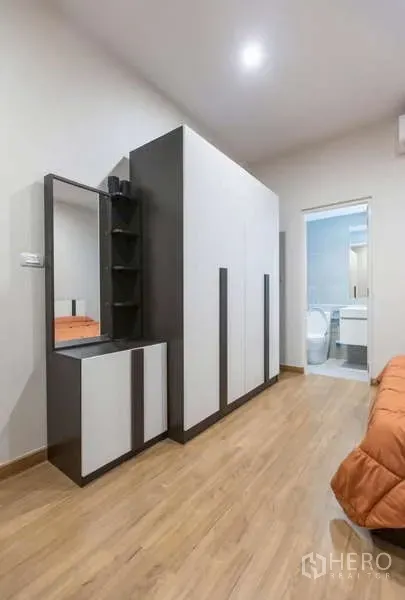 Detached House for rent or sale in Lat Phrao, Bangkok - Bedroom corridor with large wardrobe, dressing table and door to an en-suite bathroom.