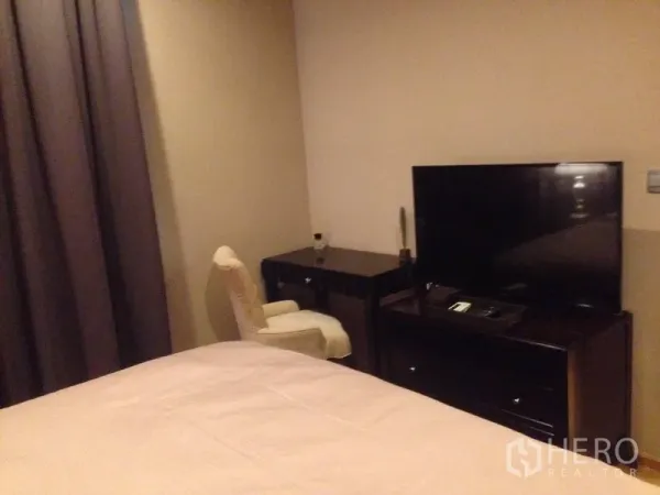 Condominium for rent in Khlong Toei, Bangkok - Bedroom corner featuring flat-screen TV, dresser and compact work desk.