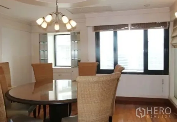 Condominium for rent in Sathon, Bangkok - Separate dining area with round table, rattan chairs, chandelier and wide windows.