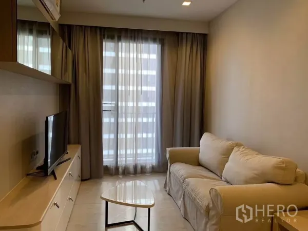 公寓 出租或出售在Watthana, Bangkok - 采光良好的客厅，米色沙发、电视柜与落地窗帘，位于Ekkamai公寓。