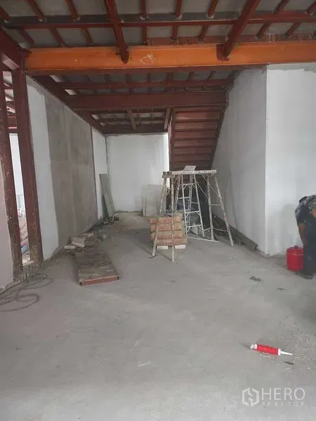 Retail Space for rent in Khlong Toei, Bangkok - Ground floor retail space under renovation with exposed beams, staircase to upper level, and construction materials.