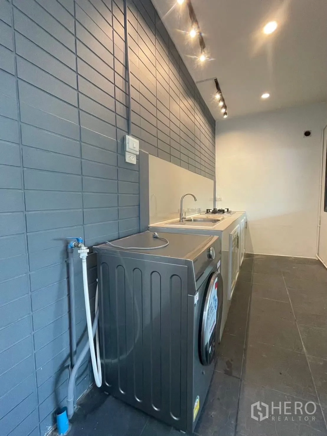 Townhouse for rent in Suan Luang, Bangkok - Kitchen and laundry zone with washing machine and long counter.