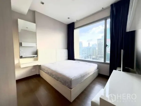 คอนโด ขายในRatchathewi, Bangkok - ห้องนอนมีหน้าต่างบานใหญ่ เห็นวิวสกายไลน์ พร้อมโต๊ะเครื่องแป้งบิลท์อิน