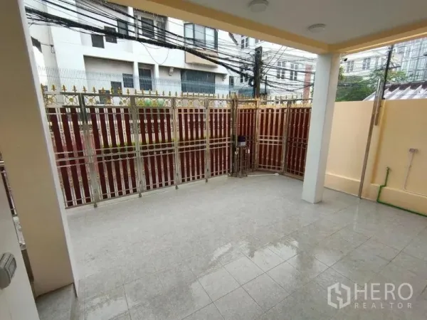 Detached House for rent in Khlong Toei, Bangkok - Covered front patio with tiled floor and an ornate metal gate at a detached house.