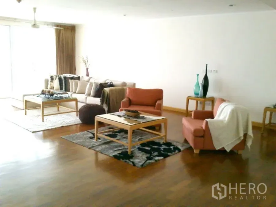 Condominium for rent in Khlong Toei, Bangkok - Living area from another angle with sofa set, armchairs and sliding balcony door.