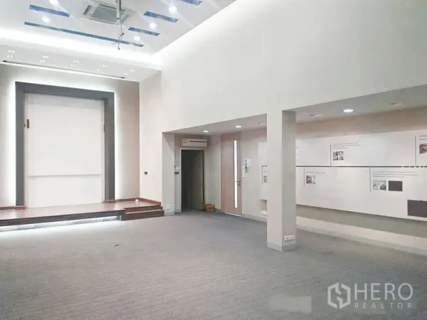 Office Space for rent in Suan Luang, Bangkok - Open presentation room with high ceiling, recessed lighting, and a small stage.