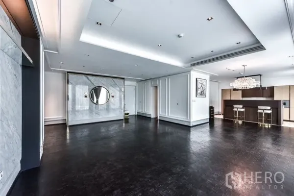 Condominium for rent in Bang Rak, Bangkok - Expansive living area flowing to the kitchen with chandelier and dark parquet floors.