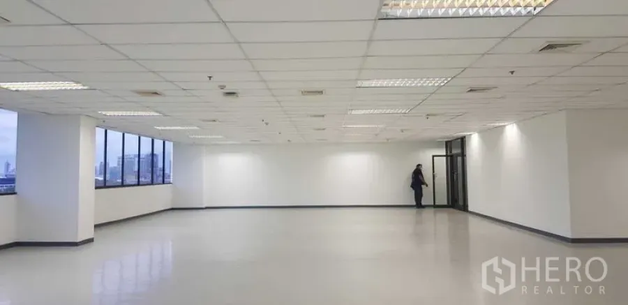 Office Space for rent in Khlong Toei, Bangkok - Open workspace with expansive windows bringing natural light and skyline views, smooth flooring and grid ceiling.