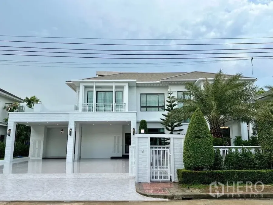 独立式住宅 出租在Lat Krabang, Bangkok - 别墅正立面再现，可见双车棚与修整花园