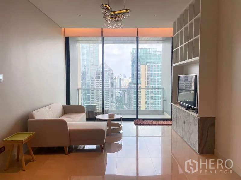 Condominium for rent in Pathum Wan, Bangkok - Bright living room with floor-to-ceiling windows, balcony and skyline view in a modern Bangkok condo.