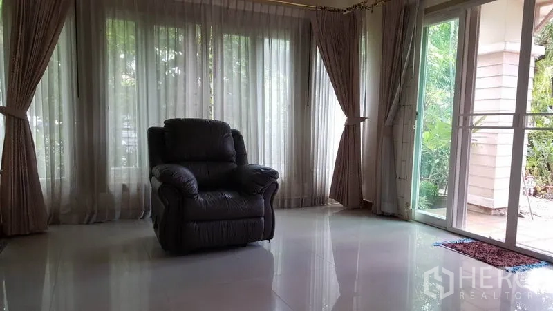 独立式住宅 出售在Mueang Nonthaburi, Nonthaburi - 采光充足的客厅，落地窗帘、推拉玻璃门与单人躺椅